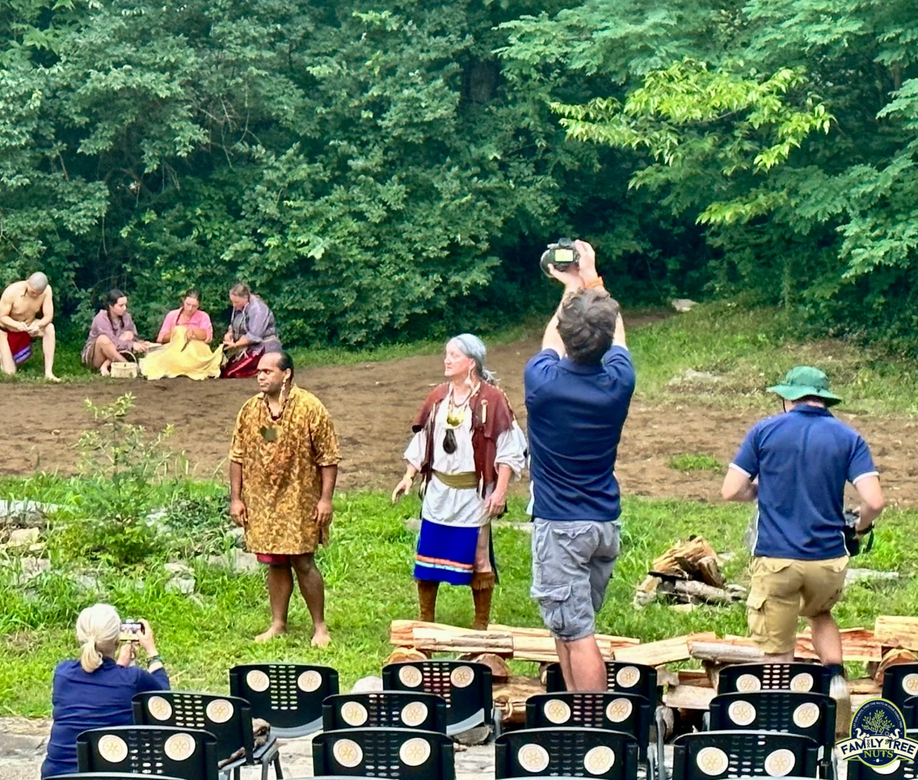 A group of people standing around in the grass.